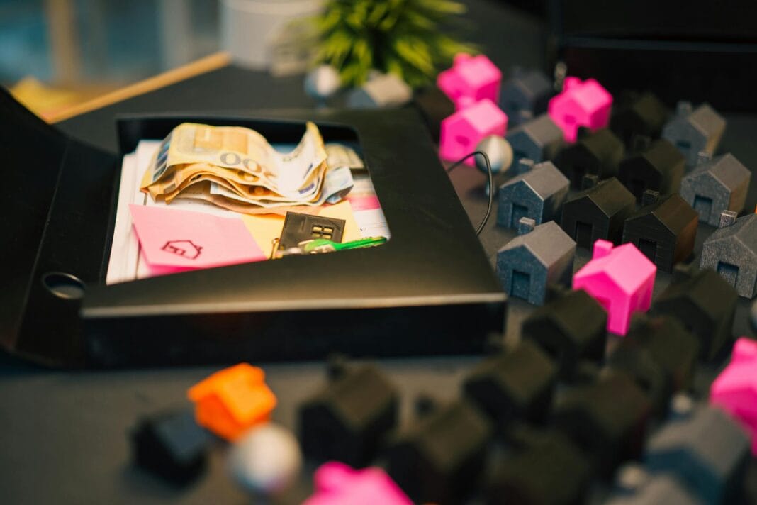 Modele domów i banknoty na stole jako symbol inwestycji w nieruchomości