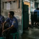 Pracownicy ochrony odpoczywają, kolega pracuje przy biurku w biurze