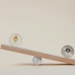 Monety Bitcoin i Ethereum balansujące na desce symbolizują rynek kryptowalut