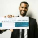 Mężczyzna trzyma kopertę z dokumentami dotyczącymi zadłużenia firmy