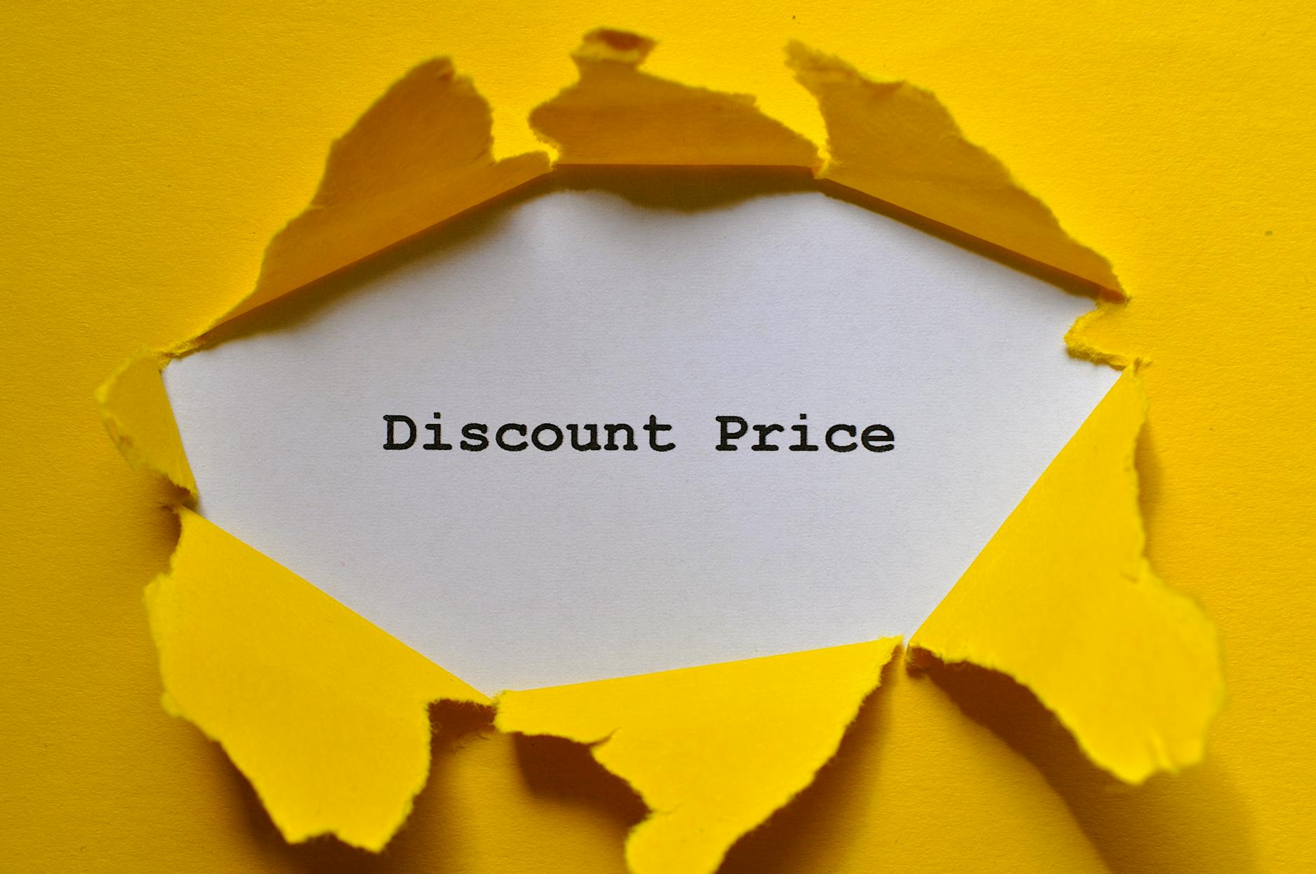 Żółty, rozdarty papier odsłania napis Discount Price