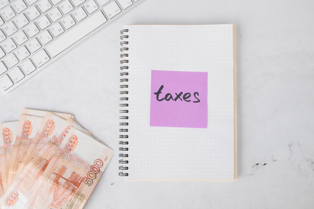Gotówka, notes i klawiatura na biurku podczas przygotowania rozliczeń podatkowyc
