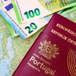Paszporty Portugalii i Austrii oraz banknoty euro na mapie Europy